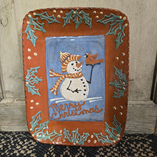 Rectangular redware plate with a snowman, cardinal, and holly leaves with the words 'Merry Christmas'