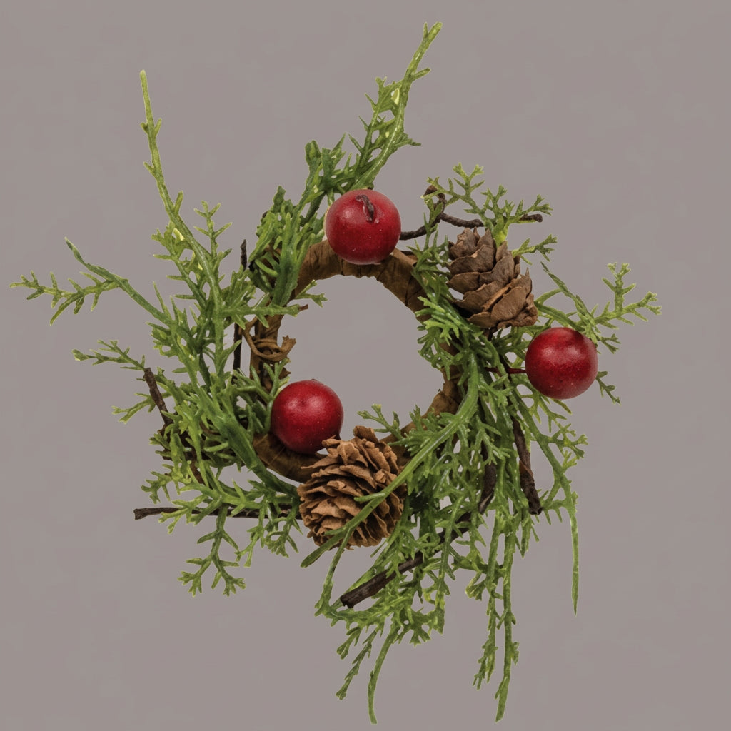 A rustic holiday wreath made of green cypress branches, decorated with three red berries and two brown pinecones, isolated on a white background.