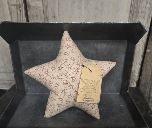 Star-shaped pillow with star pattern on a black tray against a wooden background