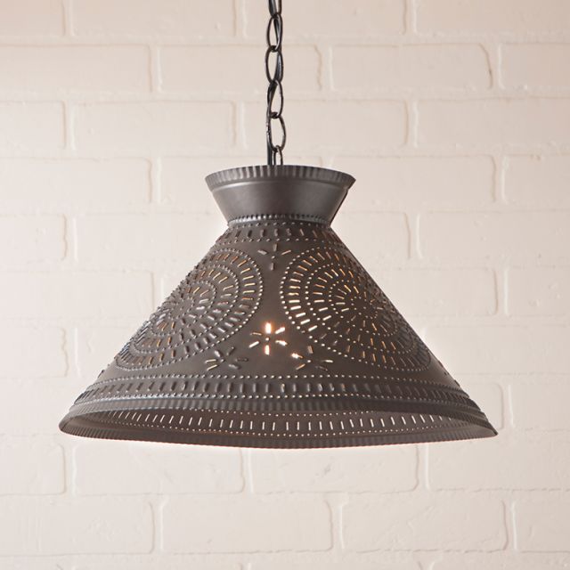 Decorative pendant light with intricate chisel design on a white brick wall background