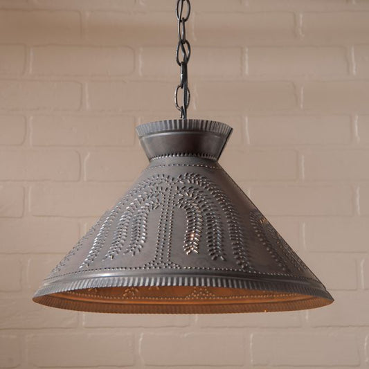 Decorative pendant light with intricate design against a brick wall background