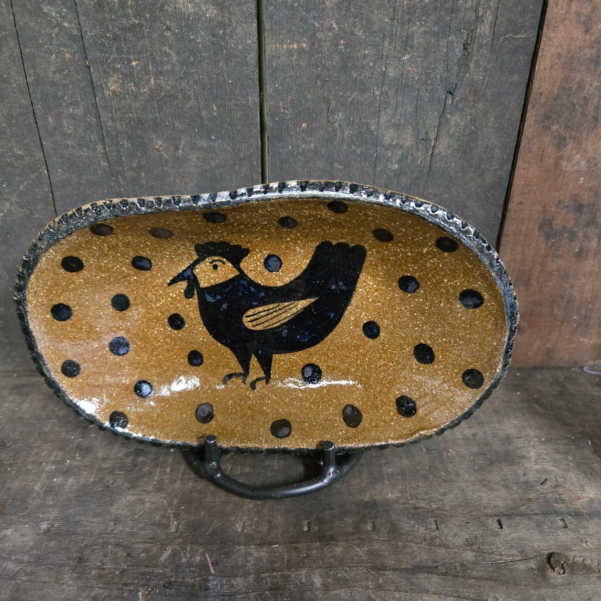 Decorative tray with black bird design on a wooden surface