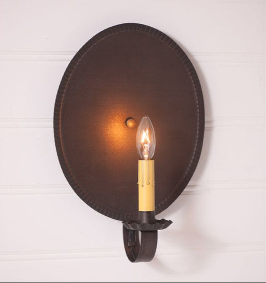 Round wall sconce with a lit bulb on a white background