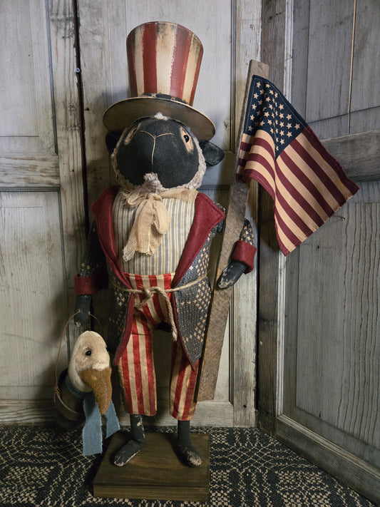 Sheep dressed as Uncle Sam with eagle in a bucket.