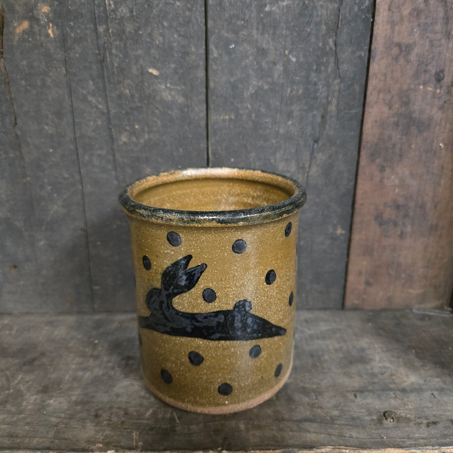 Ceramic cup with black designs on a wooden surface
