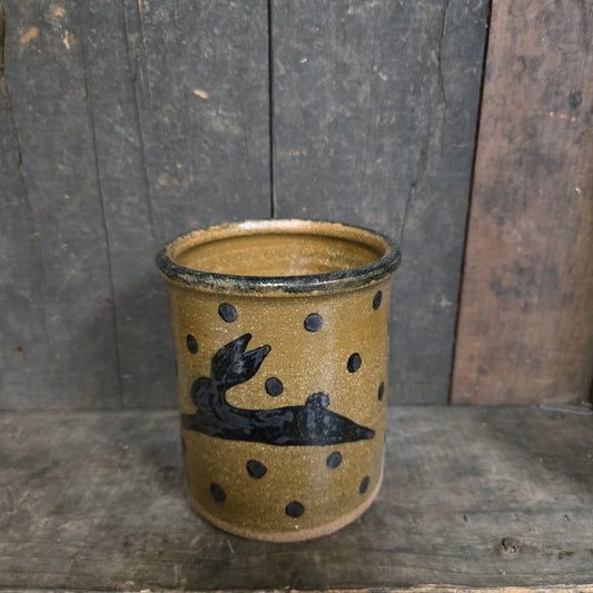 Ceramic cup with black designs on a wooden surface