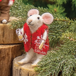 Stuffed mouse toy in a red outfit with text on a wooden stump with greenery