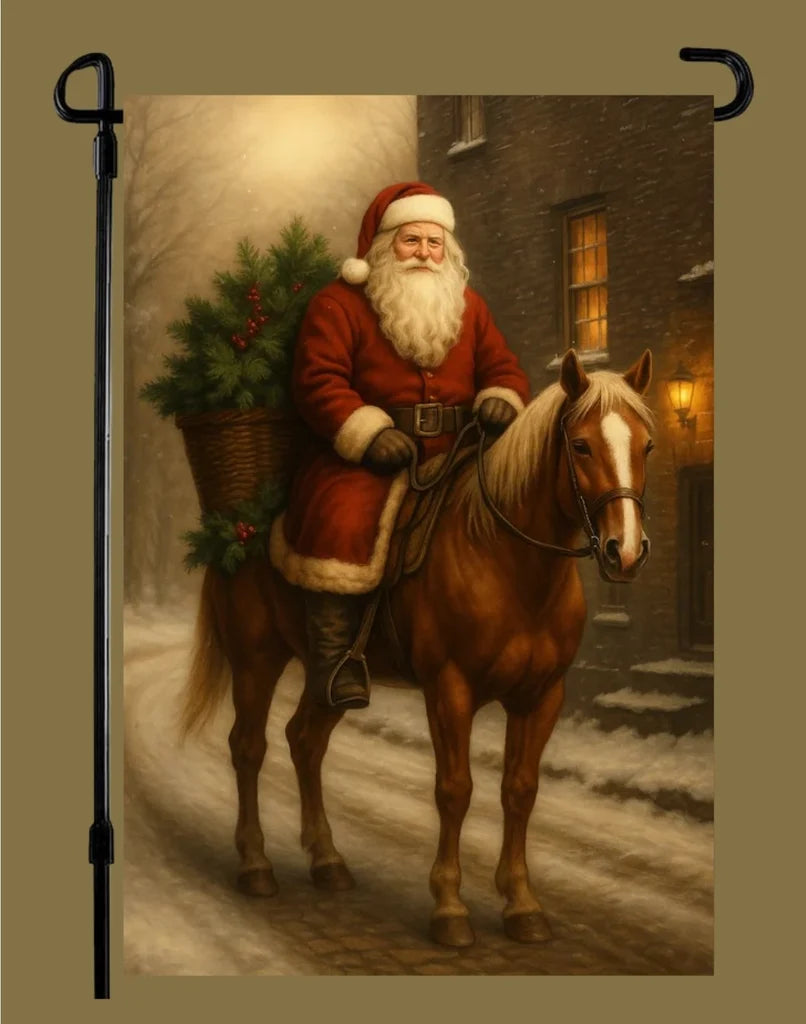 Garden flag depicting Santa in a red suit riding a chestnut horse along a snowy village street, with a basket of evergreen branches behind him.