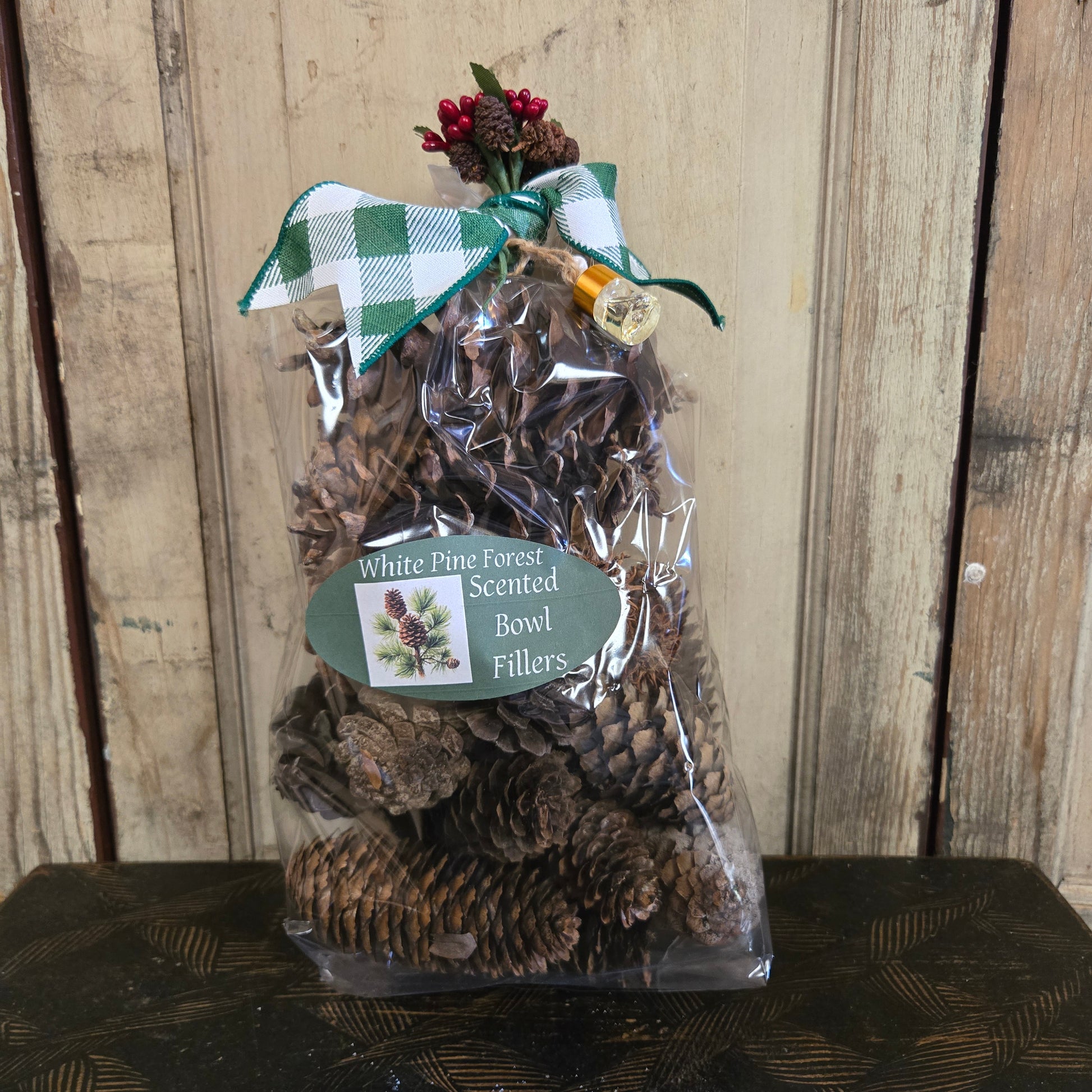 Bag of White Pine Forest Scented Bowl Fillers with a decorative tag on a wooden surface