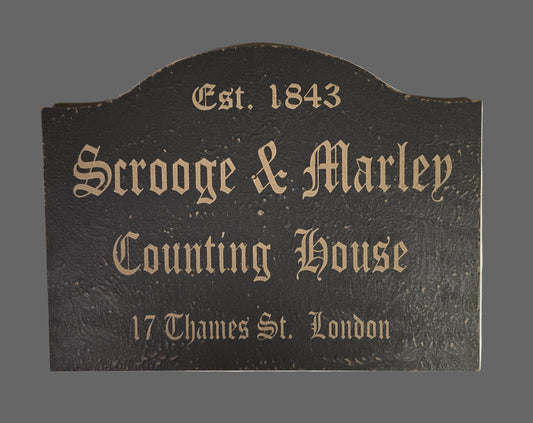 Decorative sign for 'Scrooge & Marley Counting House' with text on a dark background