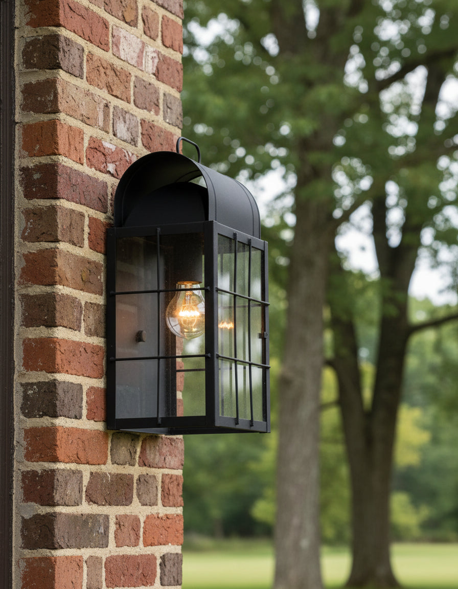 A black metal Sears Point wall light mounted on a white wall, featuring a clear glass pane door.