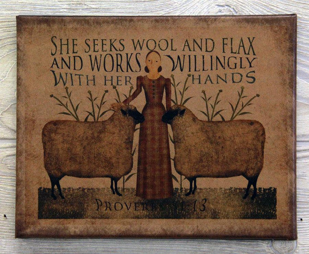 A rustic rectangular sign or print with a folk-art illustration of a woman standing between two sheep, with decorative text above and below. The sign appears to read, 'She seeks wool and flax and works willingly with her hands' and includes 'Proverbs 31:13' at the bottom.