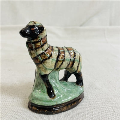 Pottery sculpture of a sheep with yellow, black, brown, and green glazing