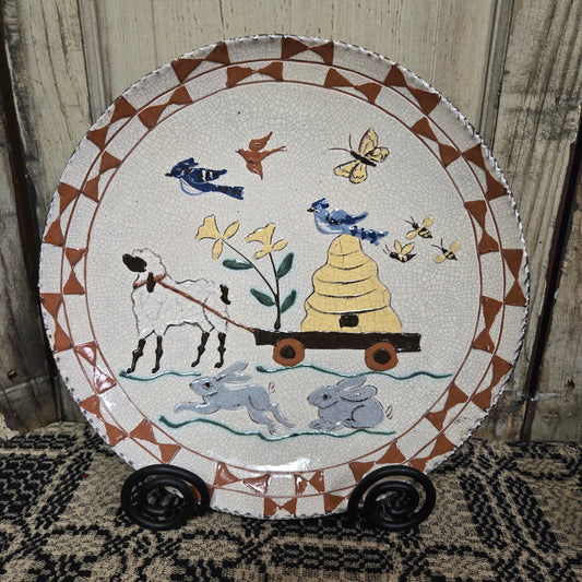 Redware plate with sheep pulling wagon with a bee skep with birds and butterflies flying overhead