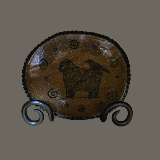 Small oval stoneware plate with sheep and crow and a unique border
