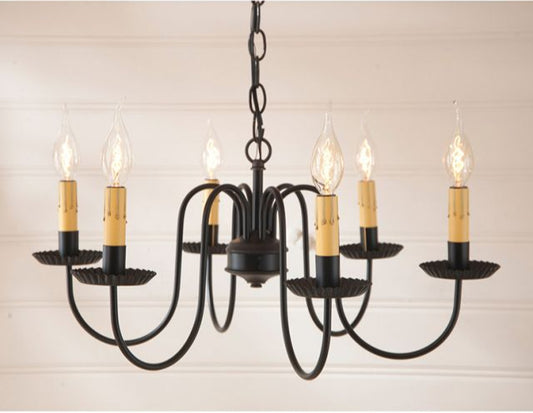 A traditional black Sheraton chandelier with six arms, turned on to display the warm glow of the bulbs, against a simple white background.