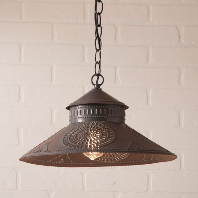 Decorative pendant light hanging against a white brick wall.