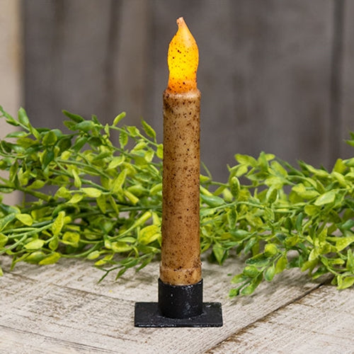 Square holder holding a battery operated ivory taper with greenery in the background