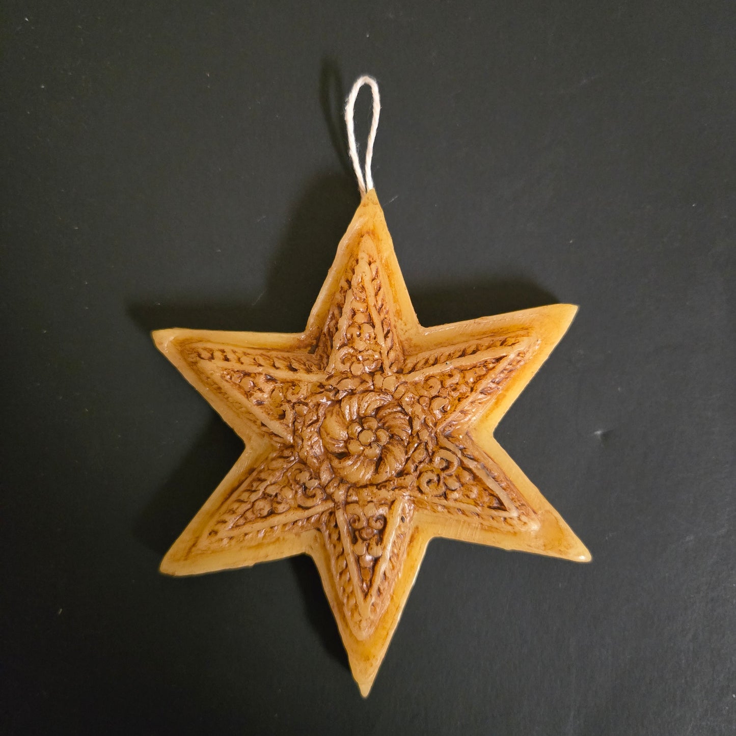 Decorative star ornament with intricate patterns on a black background