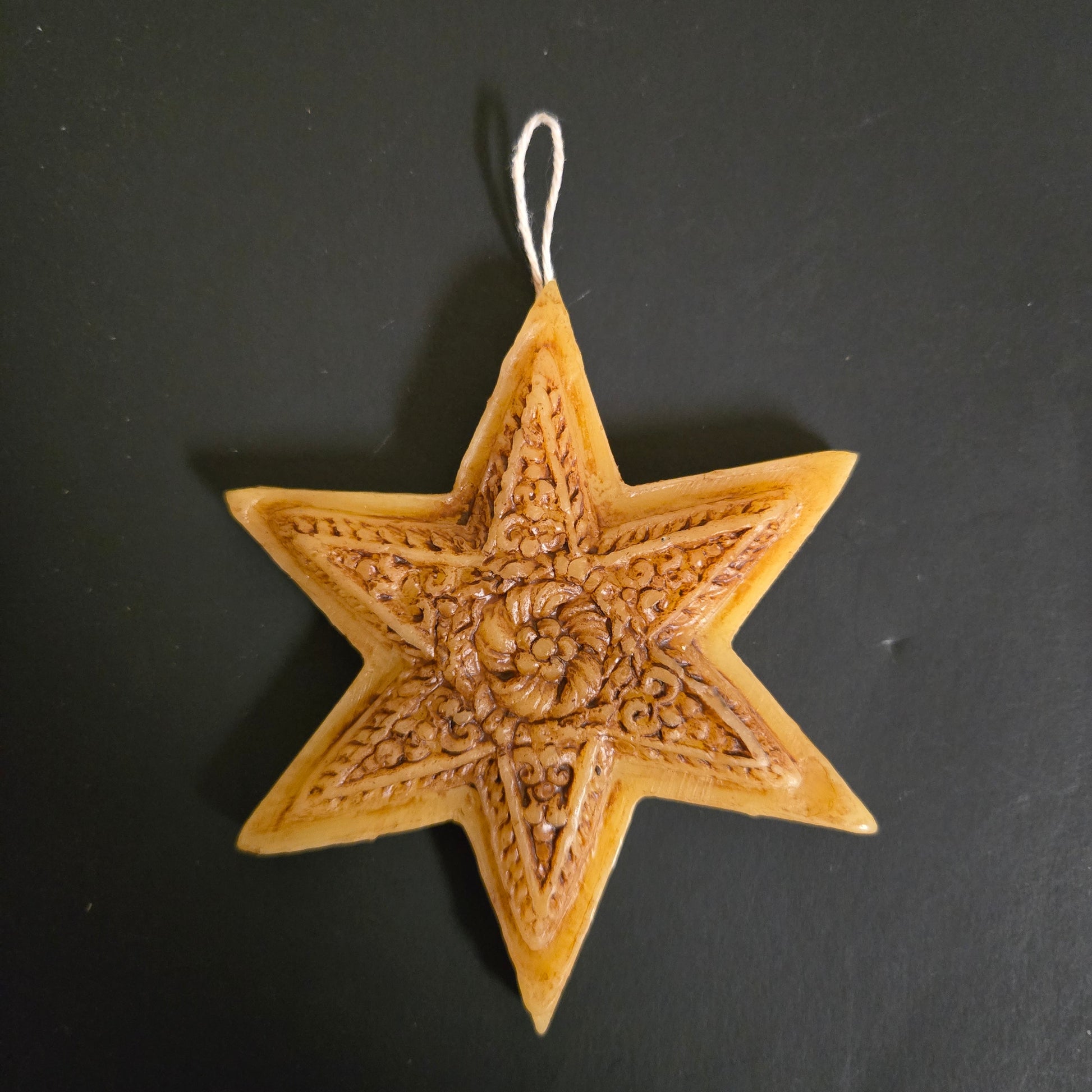 Decorative star ornament with intricate patterns on a black background