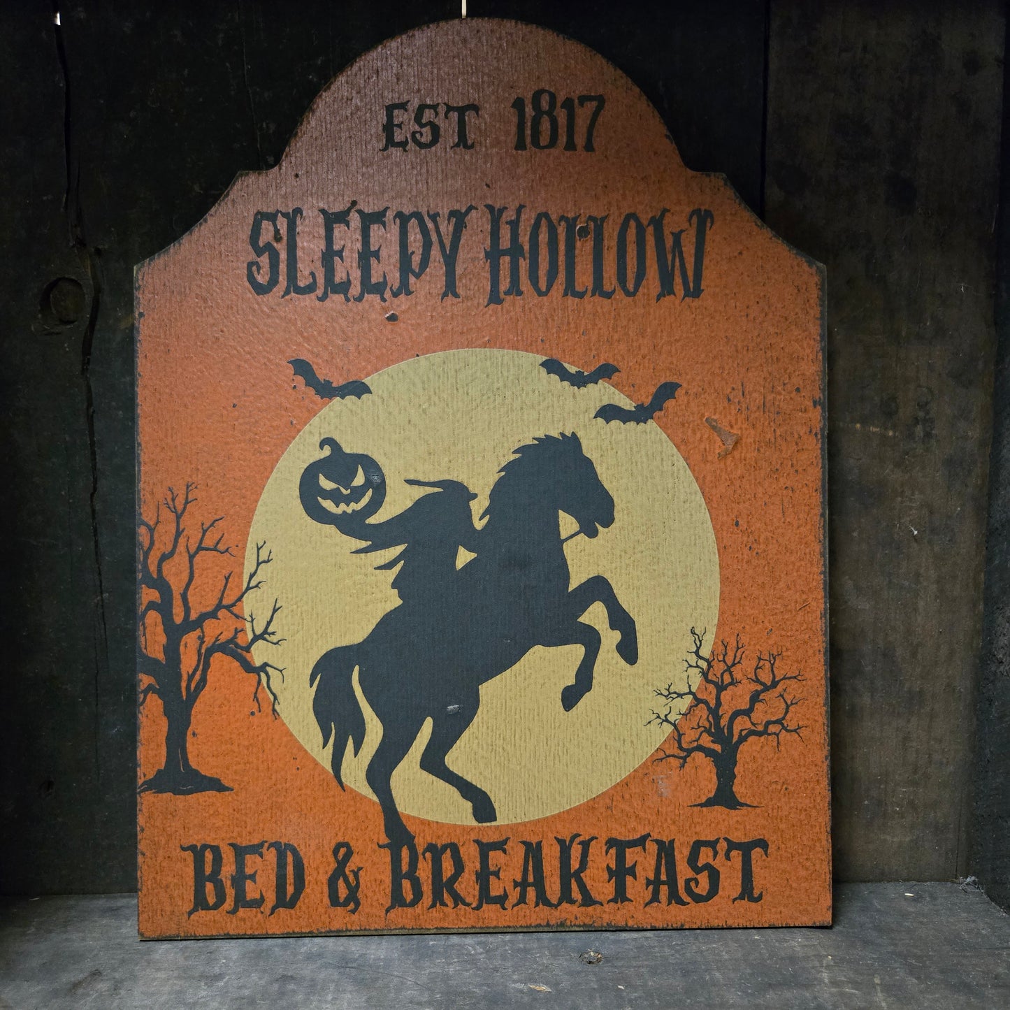 Sign with 'Sleepy Hollow' design featuring a horse and text on an orange background.