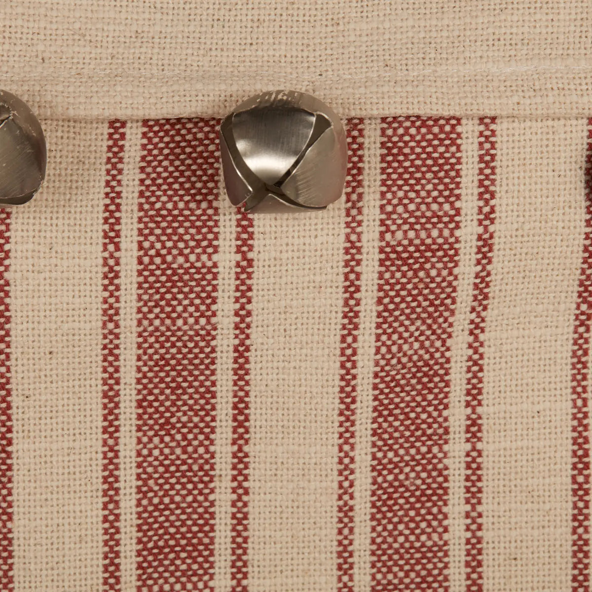 Close-up of a fabric with red and beige stripes and metal buttons.