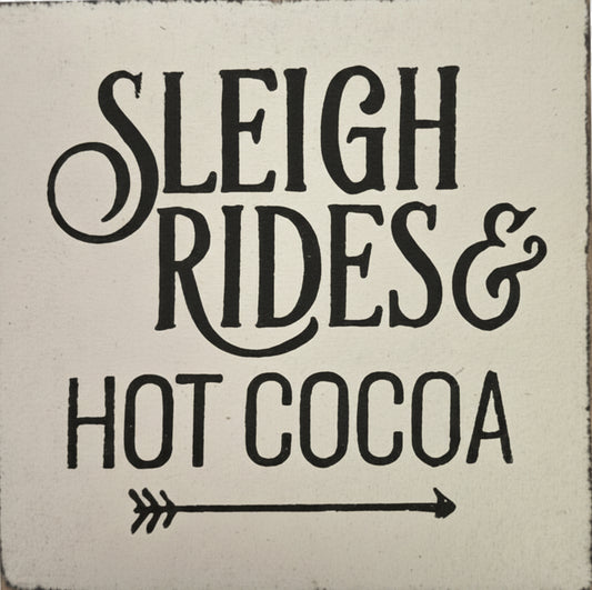 Decorative sign with 'Sleigh Rides & Hot Cocoa' text on a white background