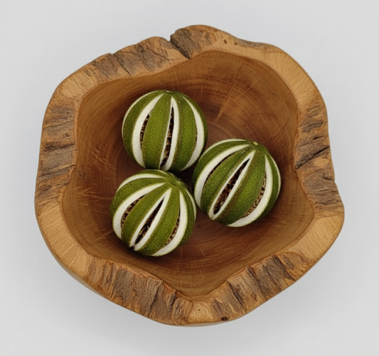 Three striped fruits in a wooden bowl on a white background