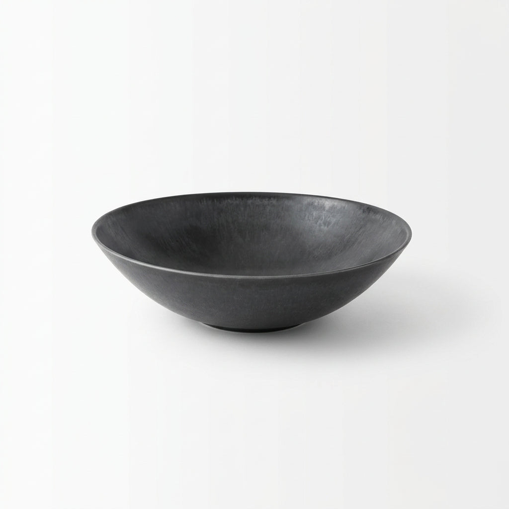 Black bowl on a textured on a white background.