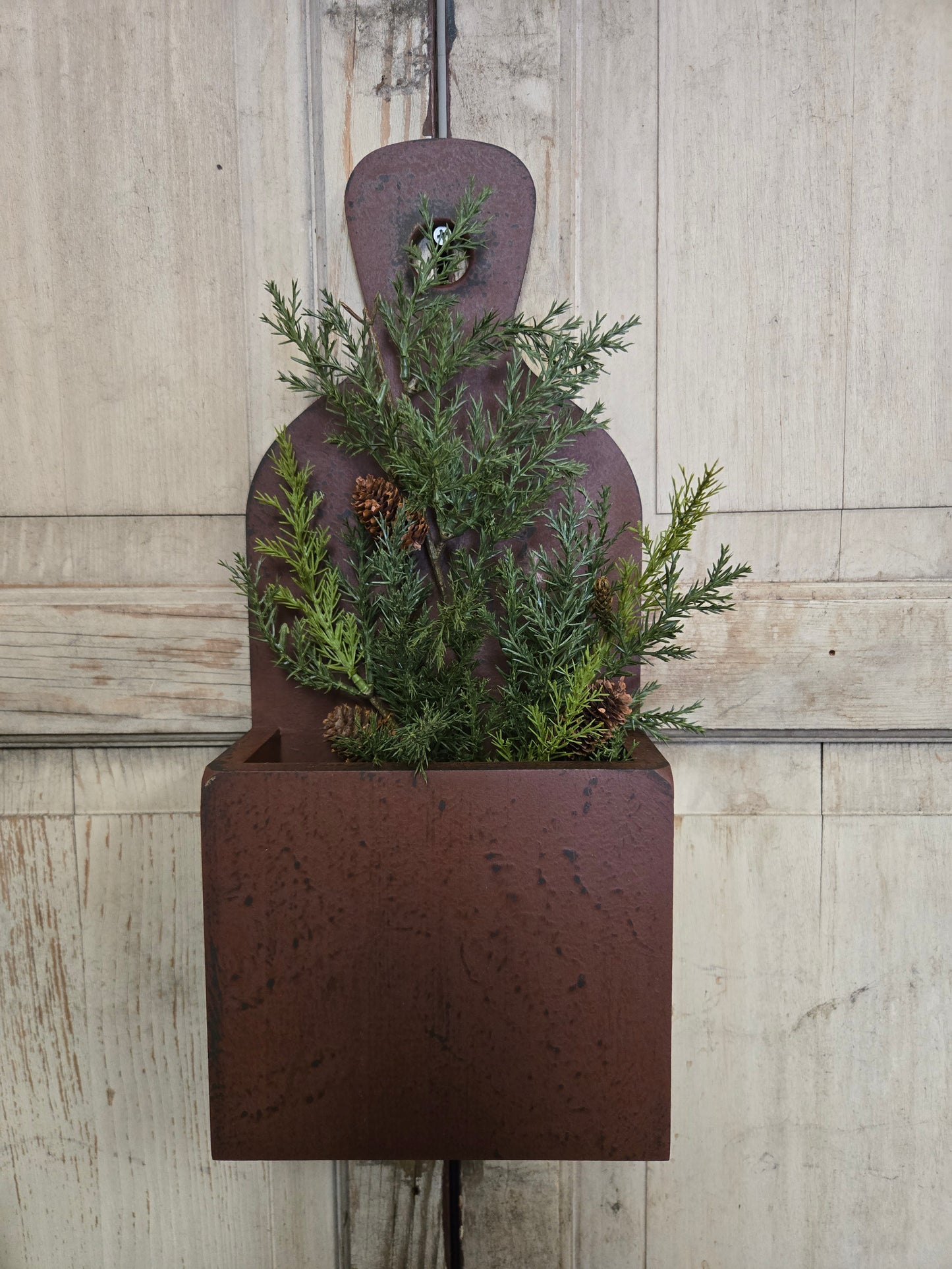 Decorative planter with greenery on a wooden floor