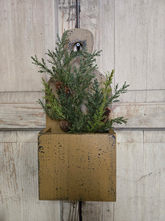 Decorative arrangement of greenery and pinecones on a textured surface