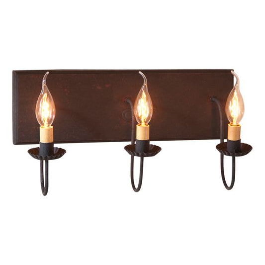 A three-light vanity light fixture with a black backplate and red textured arms, featuring E12/Candelabra sockets.