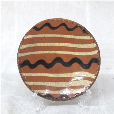 Redware plate in a primitive quill patter with brown and yellow glazing
