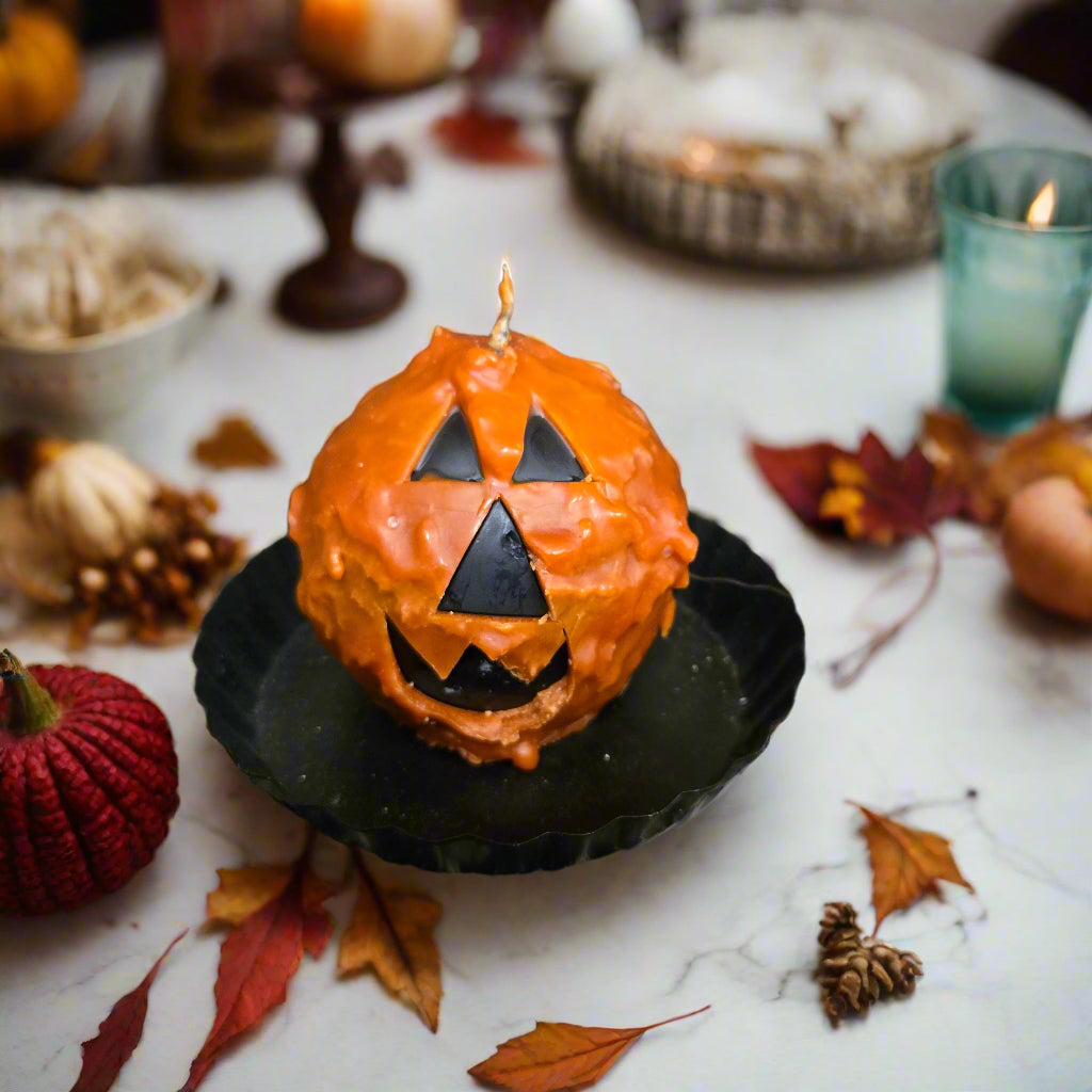 Halloween-themed cupcake with jack-o'-lantern face on a textured surface