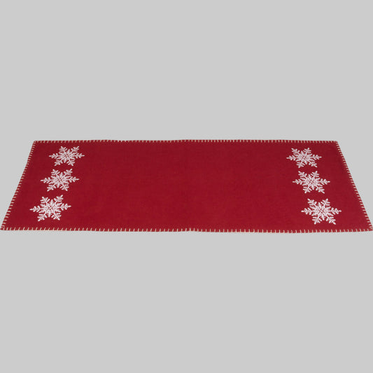 A red table runner with white snowflake embroidery on the ends, laid flat.