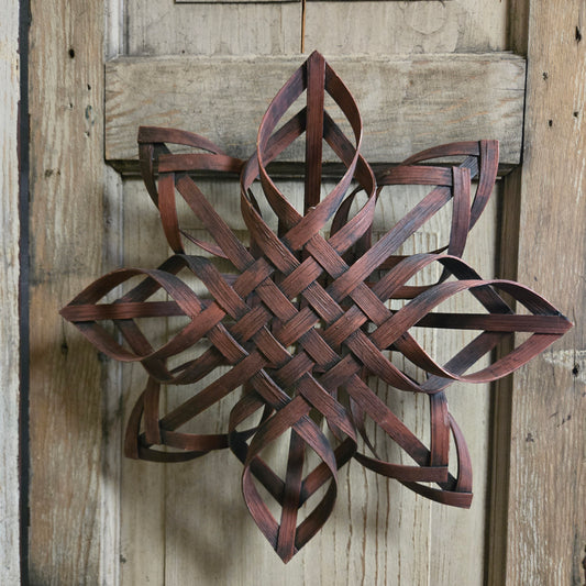 Wooden woven star wall art on a rustic wooden background