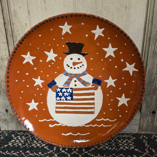 Redware plate with vibrant snowman holding a flag surrounded by stars