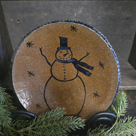 Stoneware plate with a snowman design on a dark background