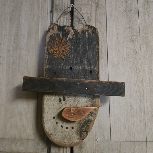 Snowman head on wire with a rusty snowflake on his hat.