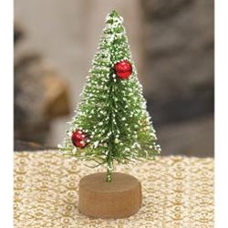 A small, green, tabletop holiday tree with red bauble ornaments and a dusting of faux-snow, standing on a round base.