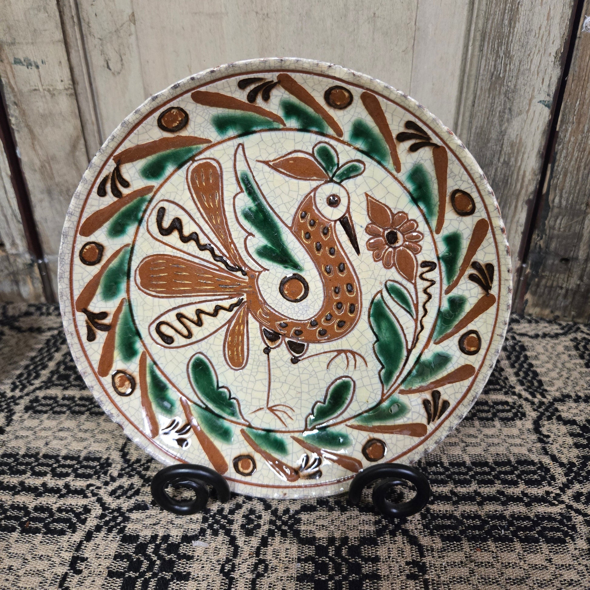 Redware plate with speckled bird and flower with an intricate border