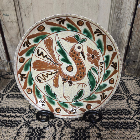 Redware plate with speckled bird and flower with an intricate border