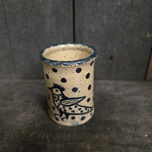 Cylindrical ceramic product with black patterns on a wooden surface