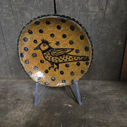 Decorative object with polka dot pattern and bird design on a wooden surface