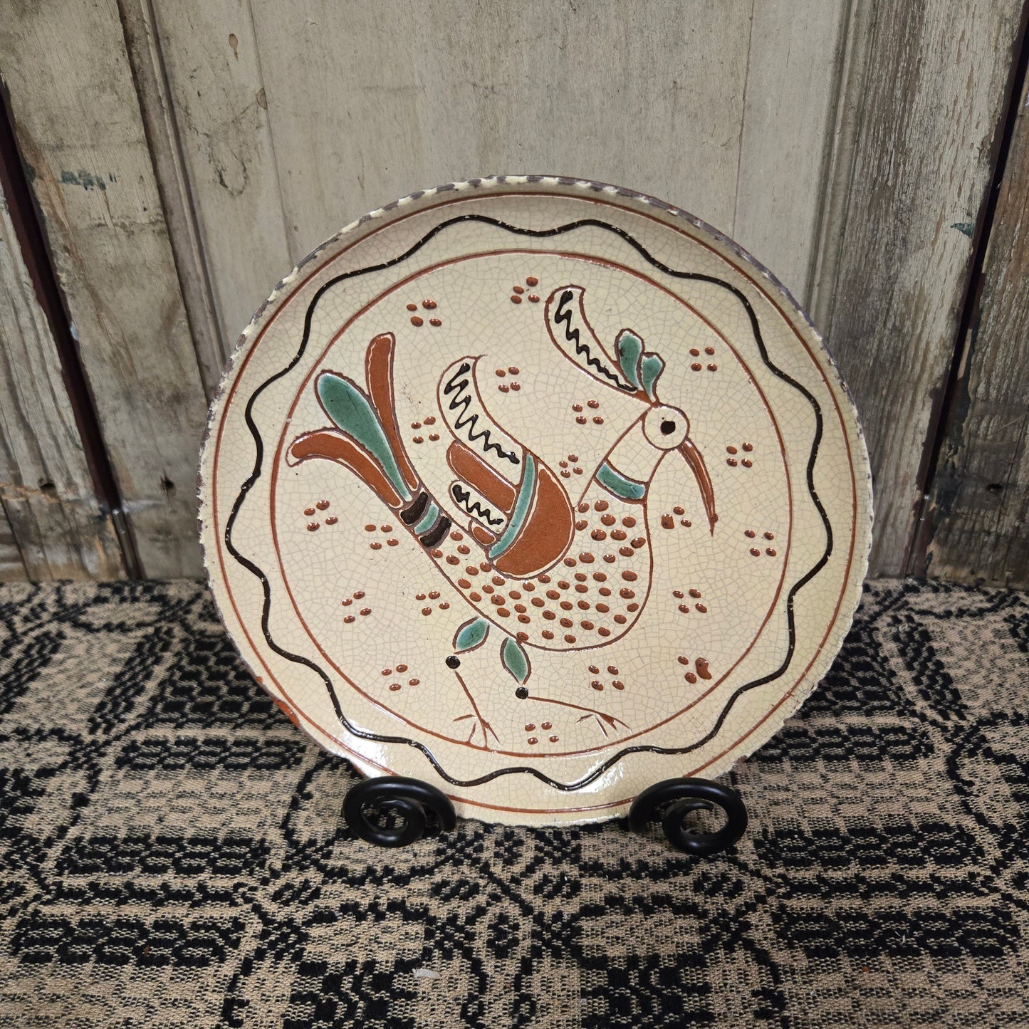 Redware plate with predominately yellow glazing with a bird with speckles