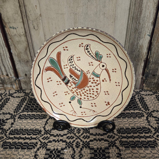 Redware plate with predominately yellow glazing with a bird with speckles