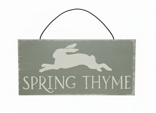 Wooden sign with 'Spring Thyme' and a rabbit silhouette on a wooden background