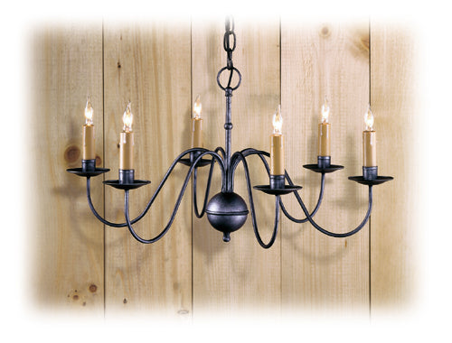A traditional-style wrought iron chandelier with six light fixtures, displayed against a wooden backdrop.