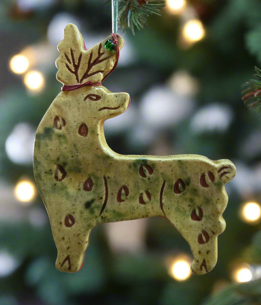 Decorative reindeer ornament on a Christmas tree with blurred lights in the background