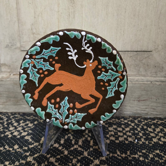 Small round redware plate with a stag and holly motif